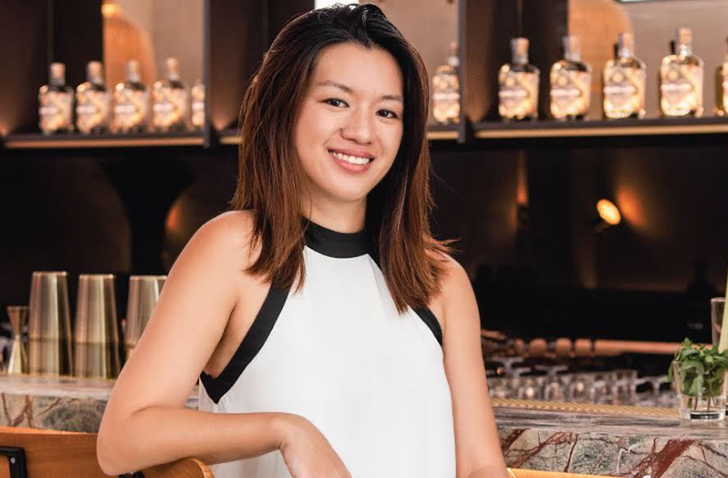 Brass Lion distiller and founder Jamie Koh sitting at a bar.